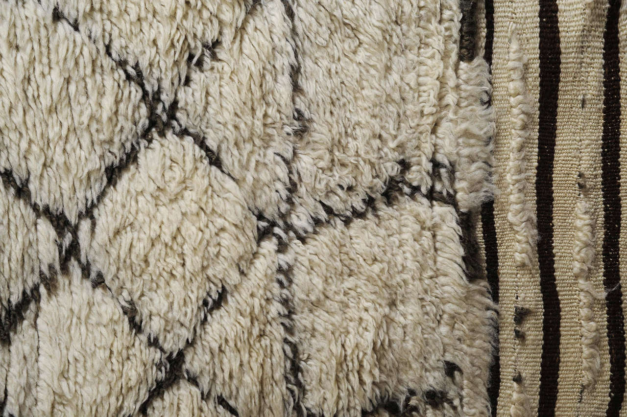 The carpets of the Beni Ouarain tribal confederacy differ from other Berber weavings in that they are woven exclusively with an ivory background and decorated with abstract geometric motifs of undyed natural wool. The high quality of the materials